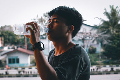 Portrait of young man drinking glass