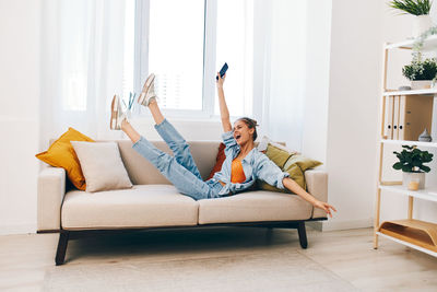 Rear view of woman sitting on sofa at home