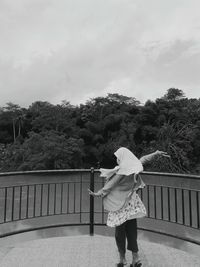 A woman is dancing on a small bridge
