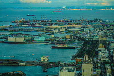 High angle view of commercial dock by sea against sky