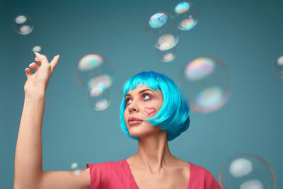 Portrait of young woman blowing bubbles