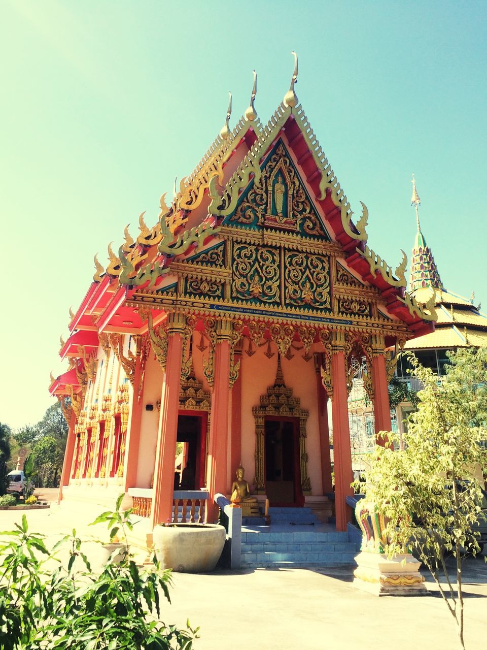 place of worship, religion, spirituality, architecture, built structure, building exterior, temple - building, clear sky, entrance, temple, facade, tree, church, low angle view, tradition, red, travel destinations, day