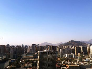 Modern buildings in city against clear blue sky