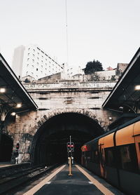 Train on bridge in city against sky