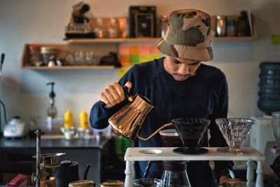 Man preparing coffee in cafe 