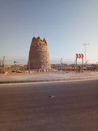 Road amidst rocks in city against clear sky