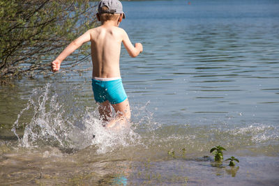 Full length of shirtless boy in water