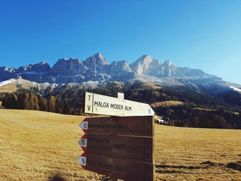 Information sign on landscape against clear blue sky