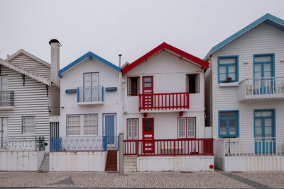 Coloured houses by street against sky in city