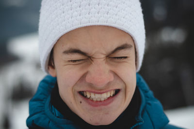 Boy with a childish joyful smile in  white hat and jacket. real portrait of a natural smiling