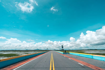 Surface level of empty road against blue sky