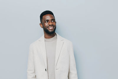 Portrait of young man standing against white background