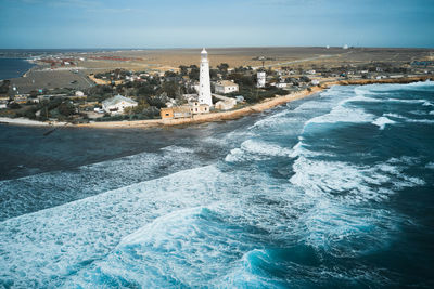 Aerial view of sea and buildings against sky