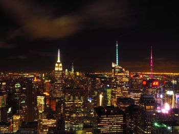 Illuminated cityscape against sky at night