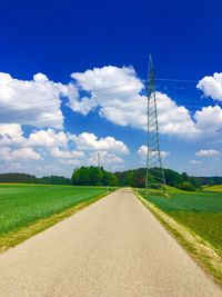 Road amidst field against sky