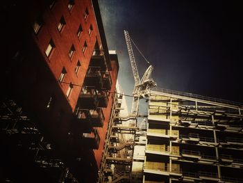 Low angle view of crane against sky