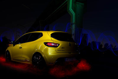 Yellow toy car on road at night