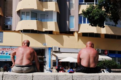 Rear view of shirtless man standing in building