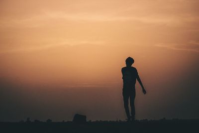 Silhouette man jumping against sky during sunset