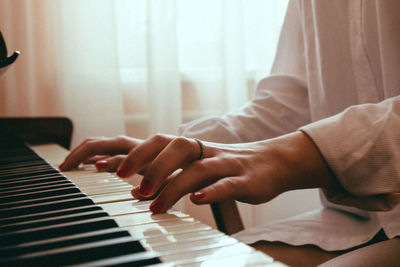 Midsection of person playing piano