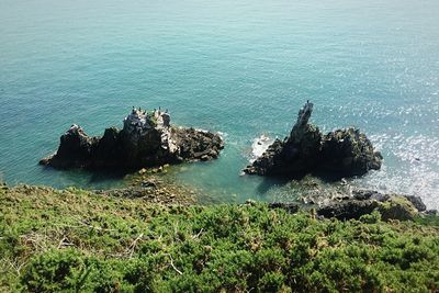High angle view of rock formation in sea against sky