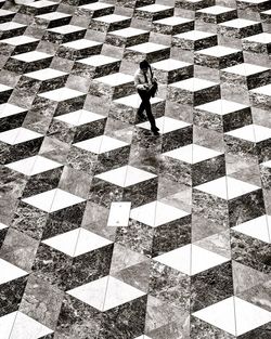 High angle view of man walking on tiled floor