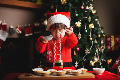 Girl preparing cookies on table during christmas