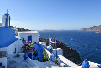 High angle view of buildings by sea against blue sky