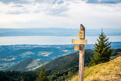 Information sign on mountain against sky