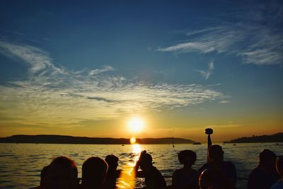 Silhouette people enjoying at beach during sunset