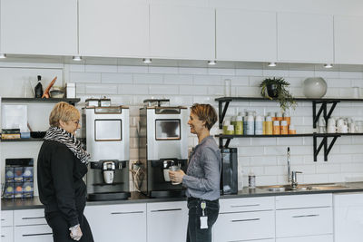 Women talking in office kitchen