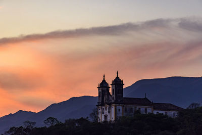 Church by building against sky during sunset