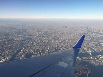 Aerial view of airplane wing over cityscape