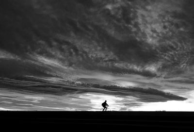Silhouette man against sky during sunset