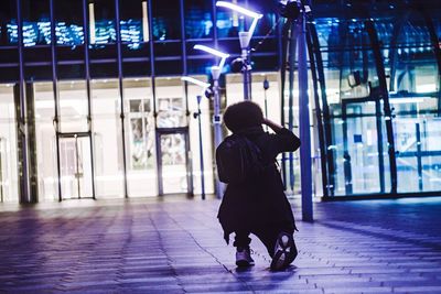 Rear view of woman standing at night