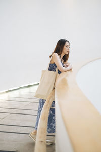 Full length of woman standing by railing outdoors