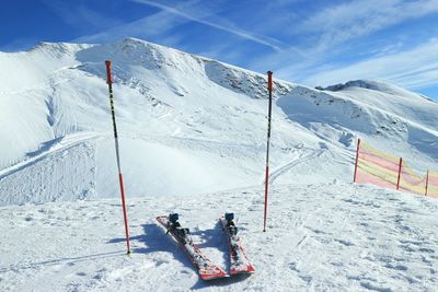 Ski poles on snow covered landscape during winter