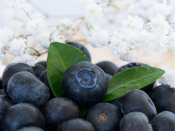 Blueberries by flowers on table