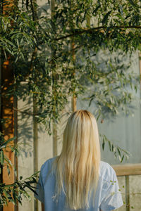 Rear view of woman standing against plants
