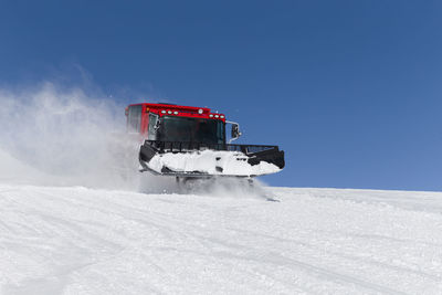 Car on snow covered mountain against sky