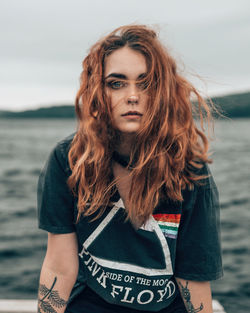 Portrait of beautiful young woman against sea