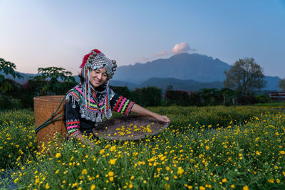 Woman with yellow flowers on field