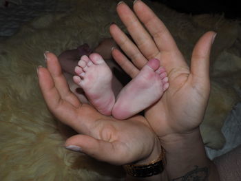 High angle view of baby hand on bed