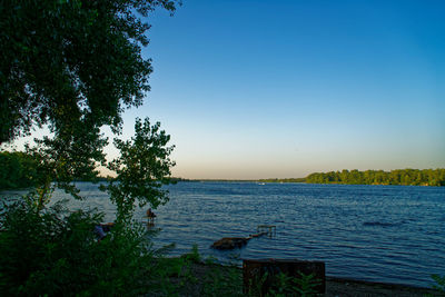 Scenic view of lake against clear blue sky