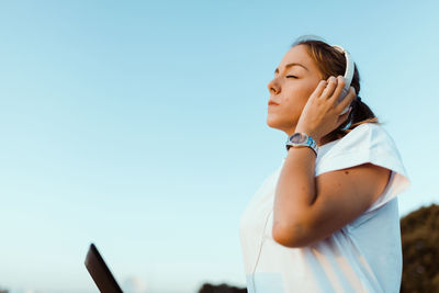 Woman looking at camera against clear sky