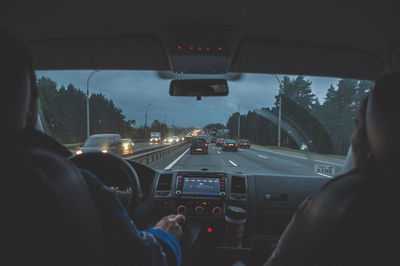 Rear view of man driving car on road