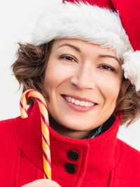 Close-up of young woman wearing hat against white background