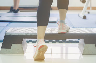 Low section of women standing on tiled floor