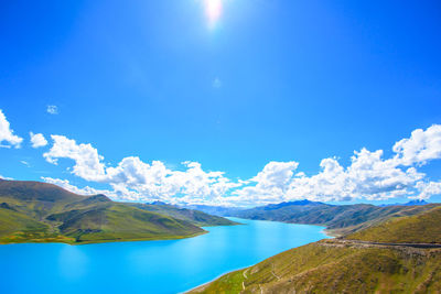 Scenic view of lake and mountains against blue sky