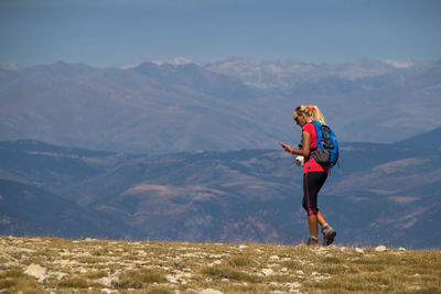 Woman with mountain range against sky